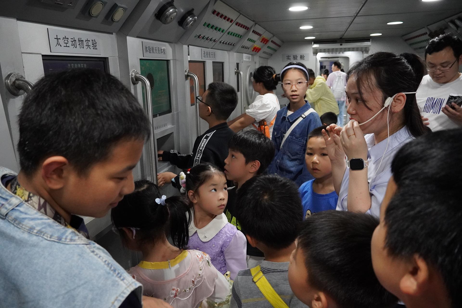 科技辅导员带领青少年参观“空间站综合演示”展项