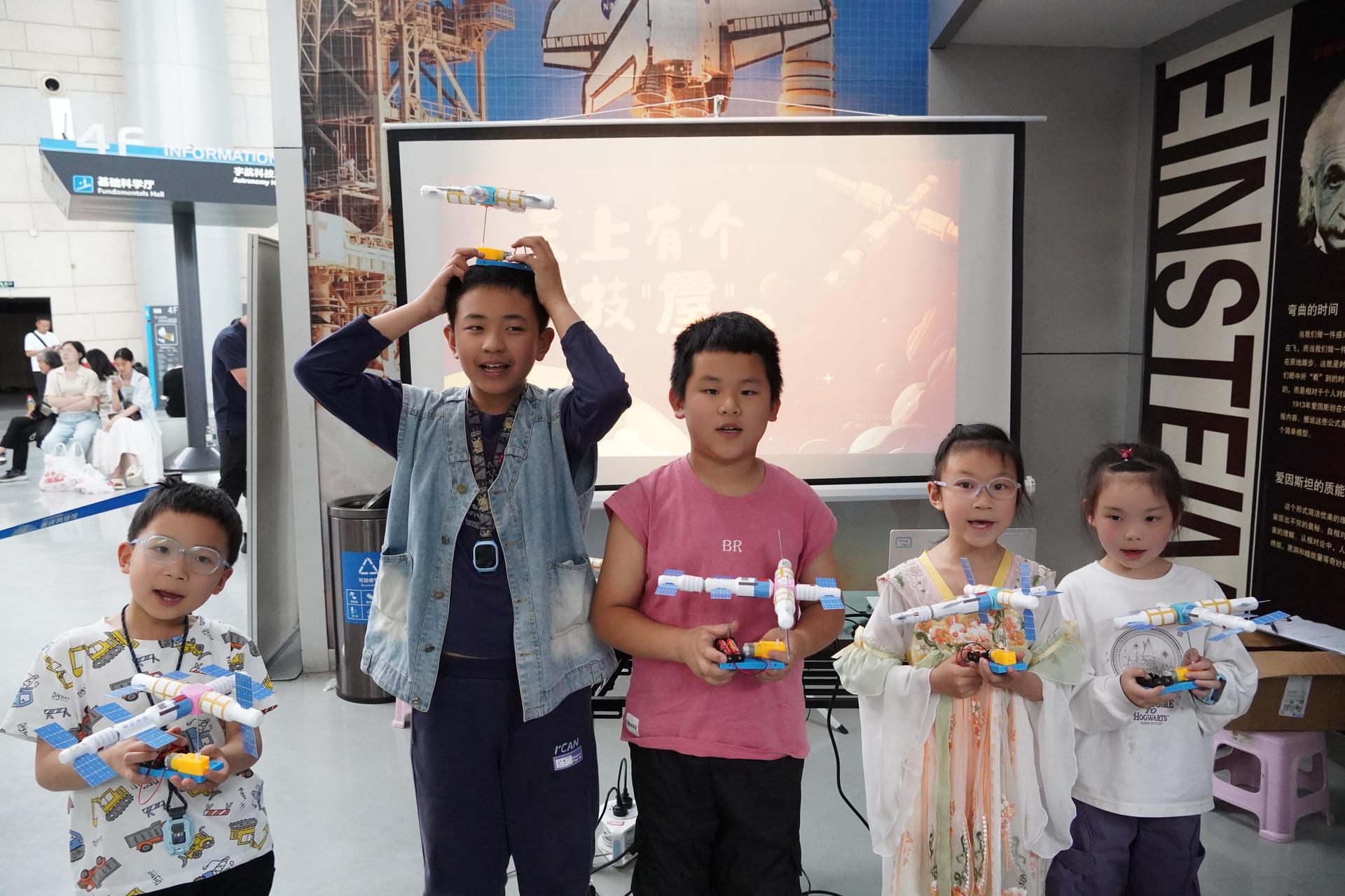 青少年展示自己制作的天宫空间站模型