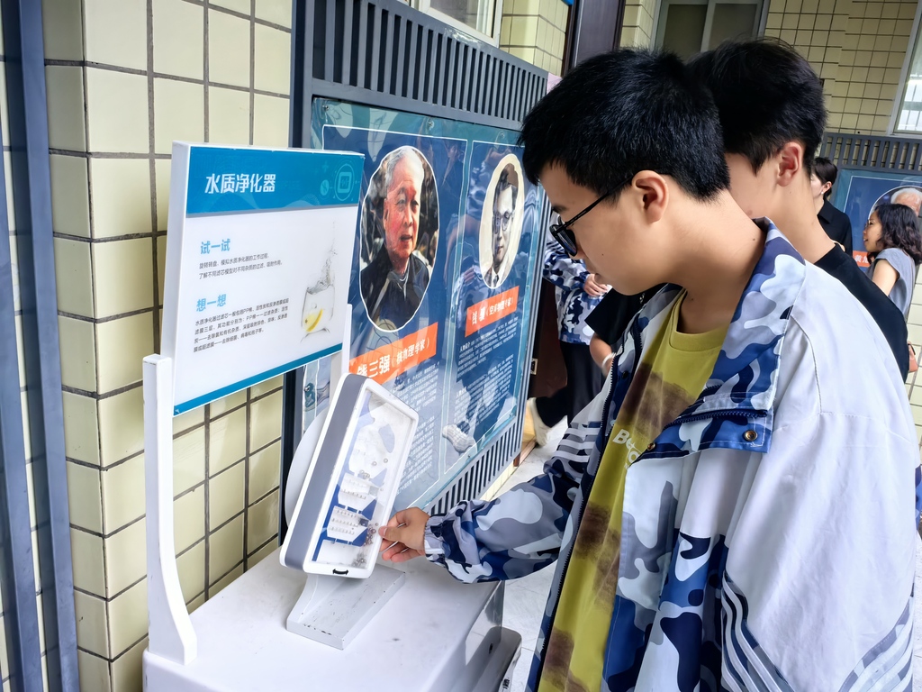 同学们在互动体验展区体验展品